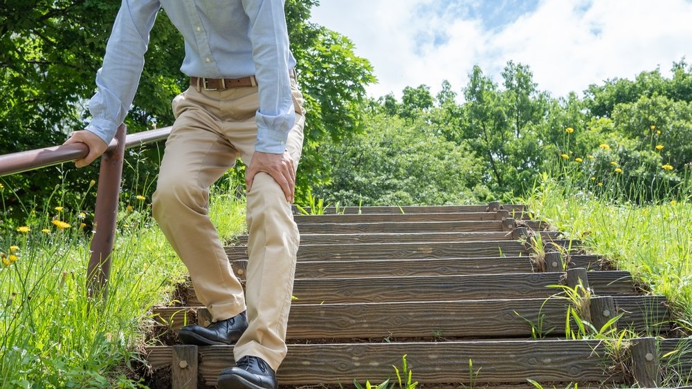 Young adult experiencing knee joint pain due to sedentary lifestyle